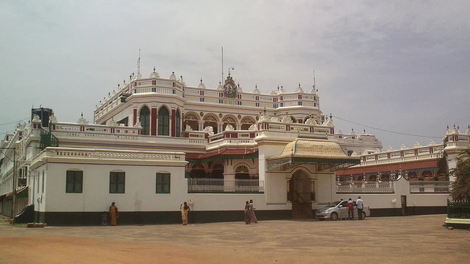 A pillared Chettiar mansion facade with carved teak doors on a village street in Chettinad