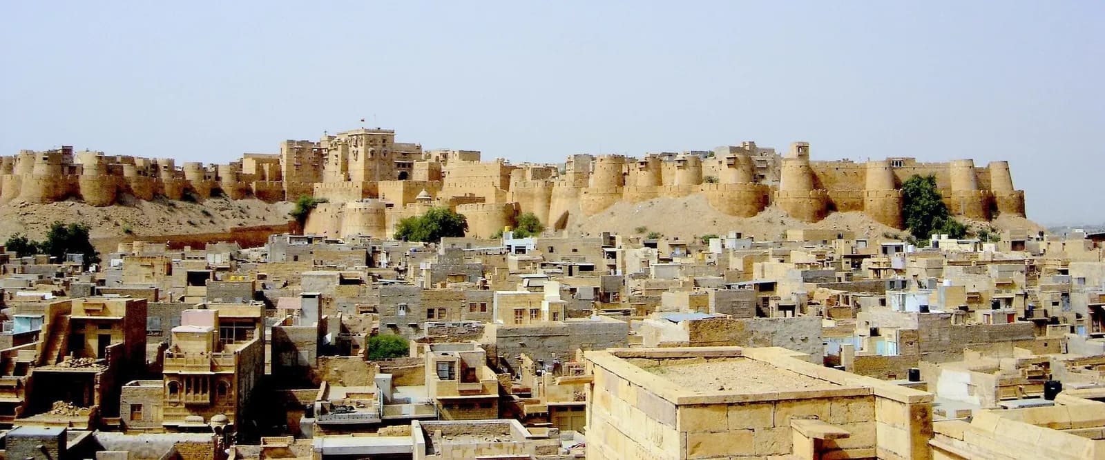 Jaisalmer Fort's golden sandstone bastions above the desert town at sunset