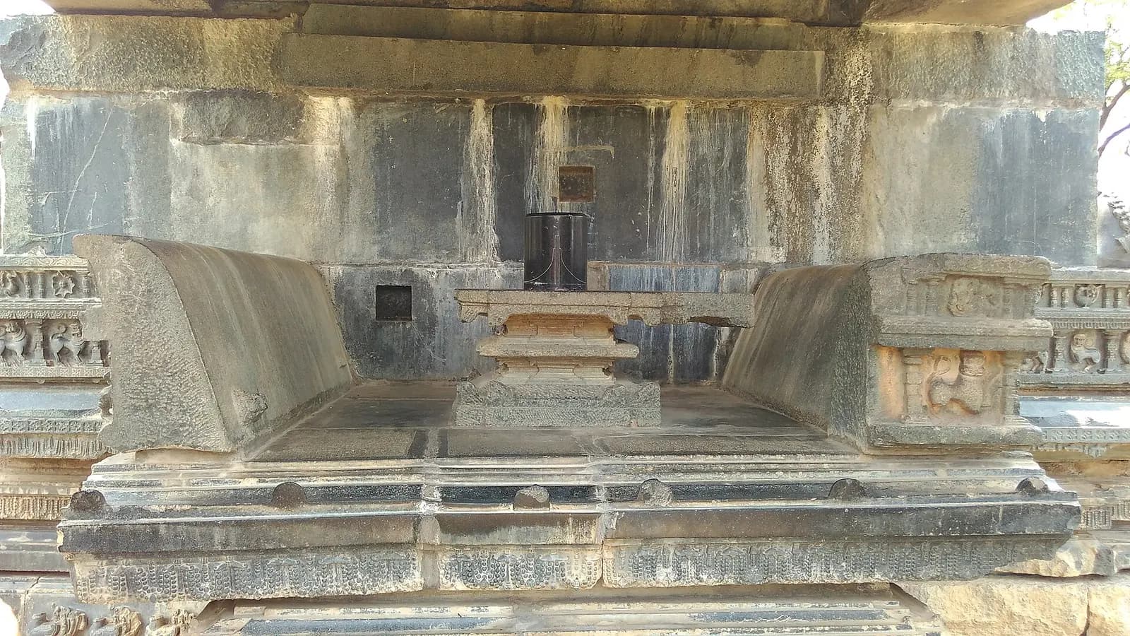 A carved Kakatiya stone gateway standing among ruins inside Warangal Fort