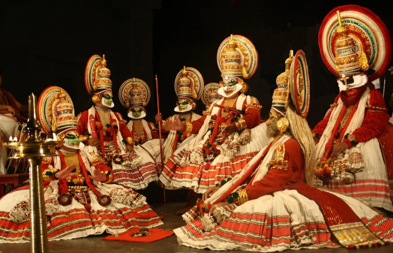 Kathakali performers in painted make-up and layered costume during a night performance in Kerala