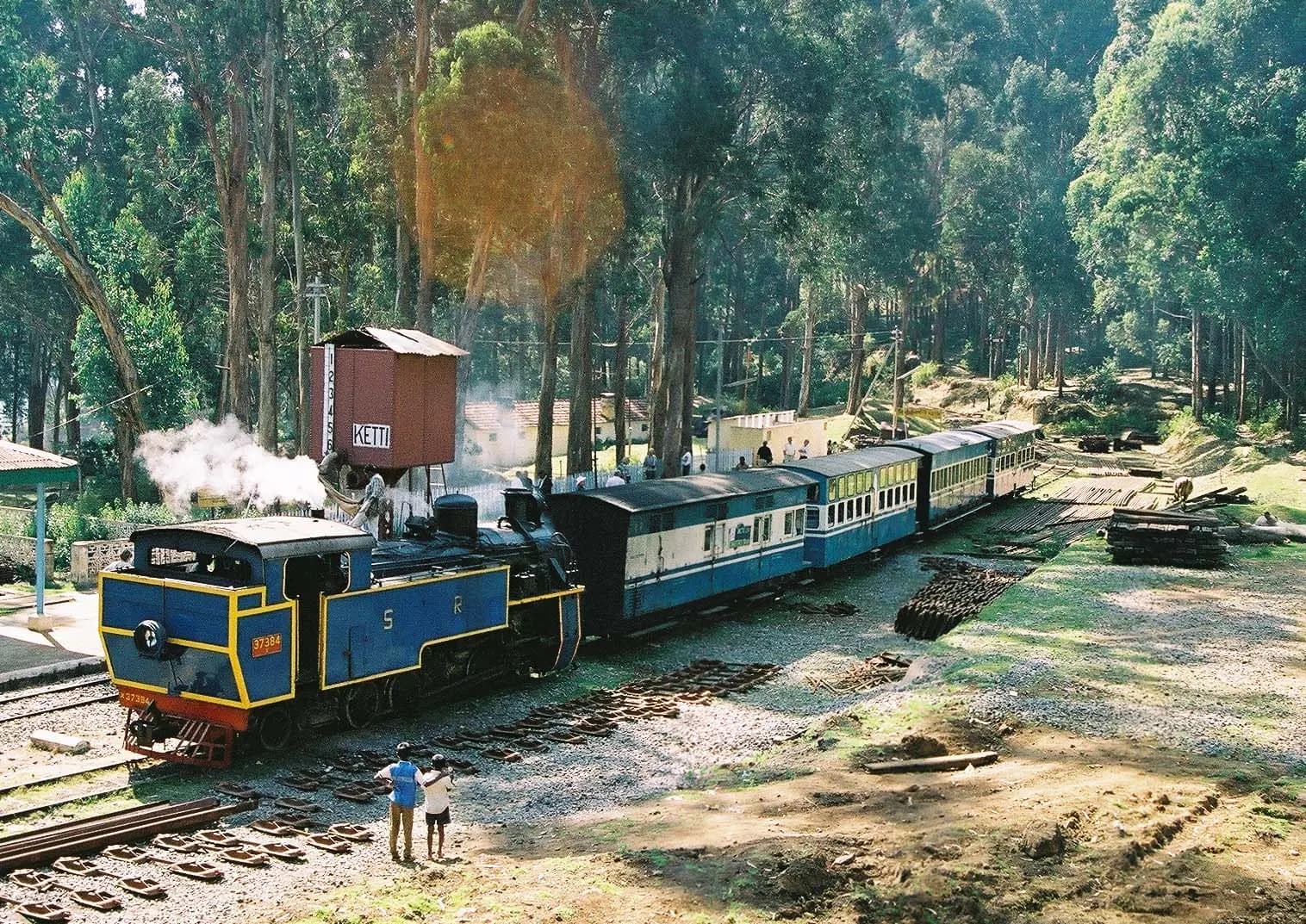 Blue carriages of the Nilgiri Mountain Railway climbing through the hills towards Ooty