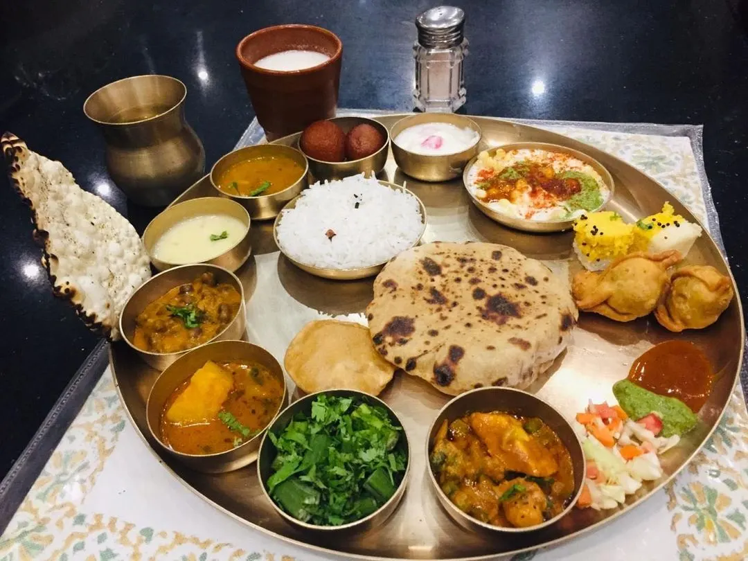 Indian thali of rice, dal, vegetable curries, chutneys and breads served in small steel bowls