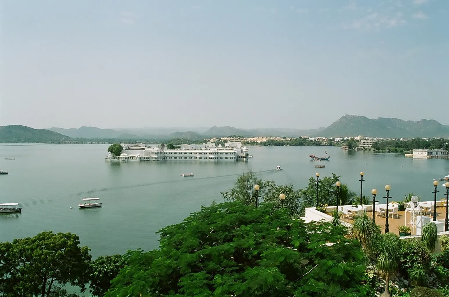 Boats on Lake Pichola at Udaipur with the City Palace and island palaces behind