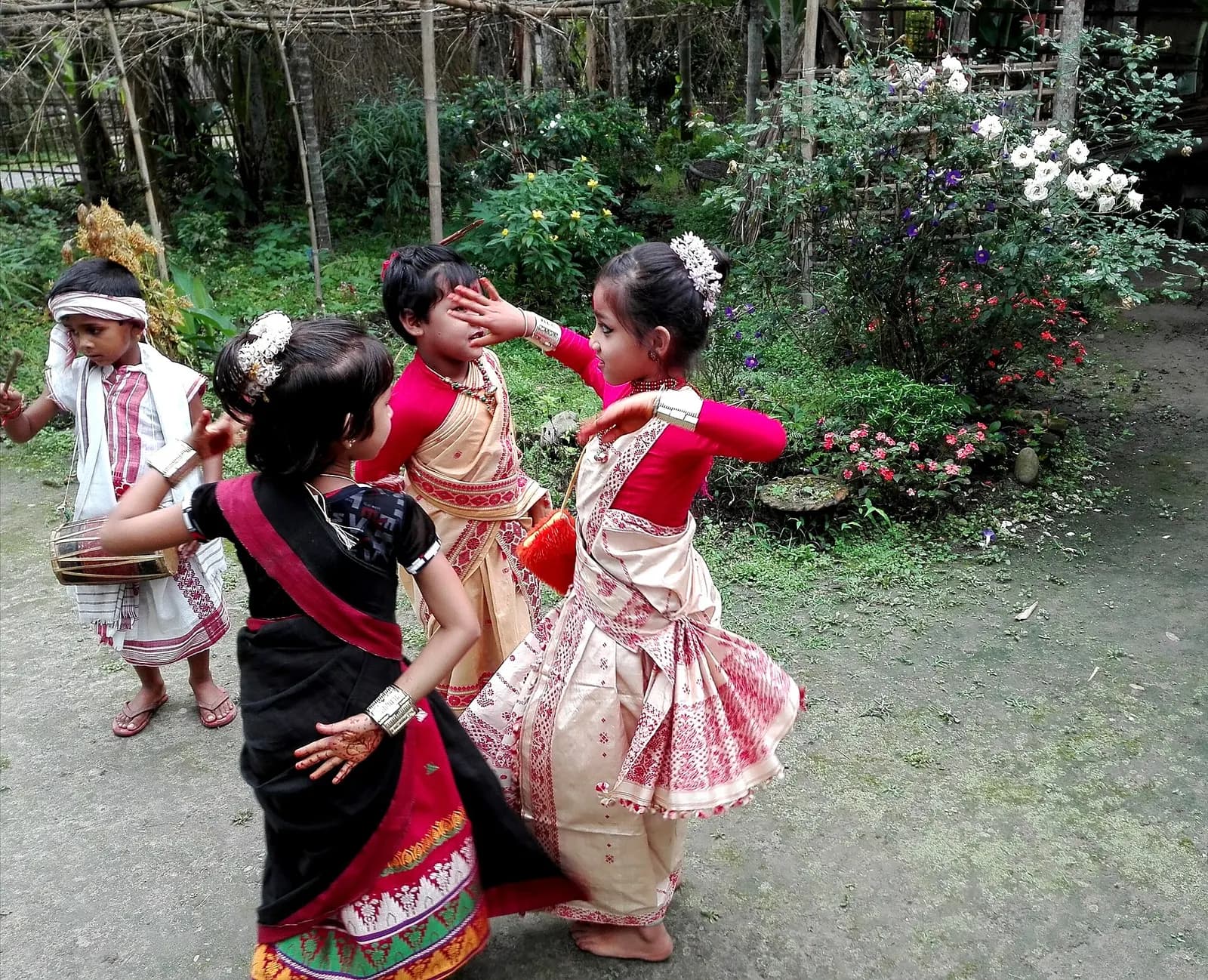 Assamese dancers in muga silk performing Bihu to dhol drums in mid-April