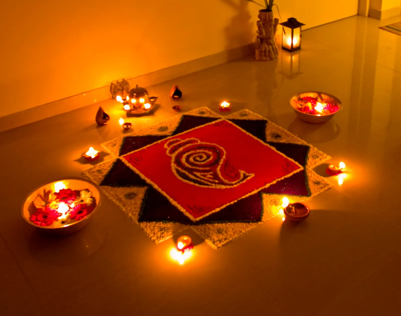 Rows of oil lamps and rangoli lit for Diwali on the night of Lakshmi Puja