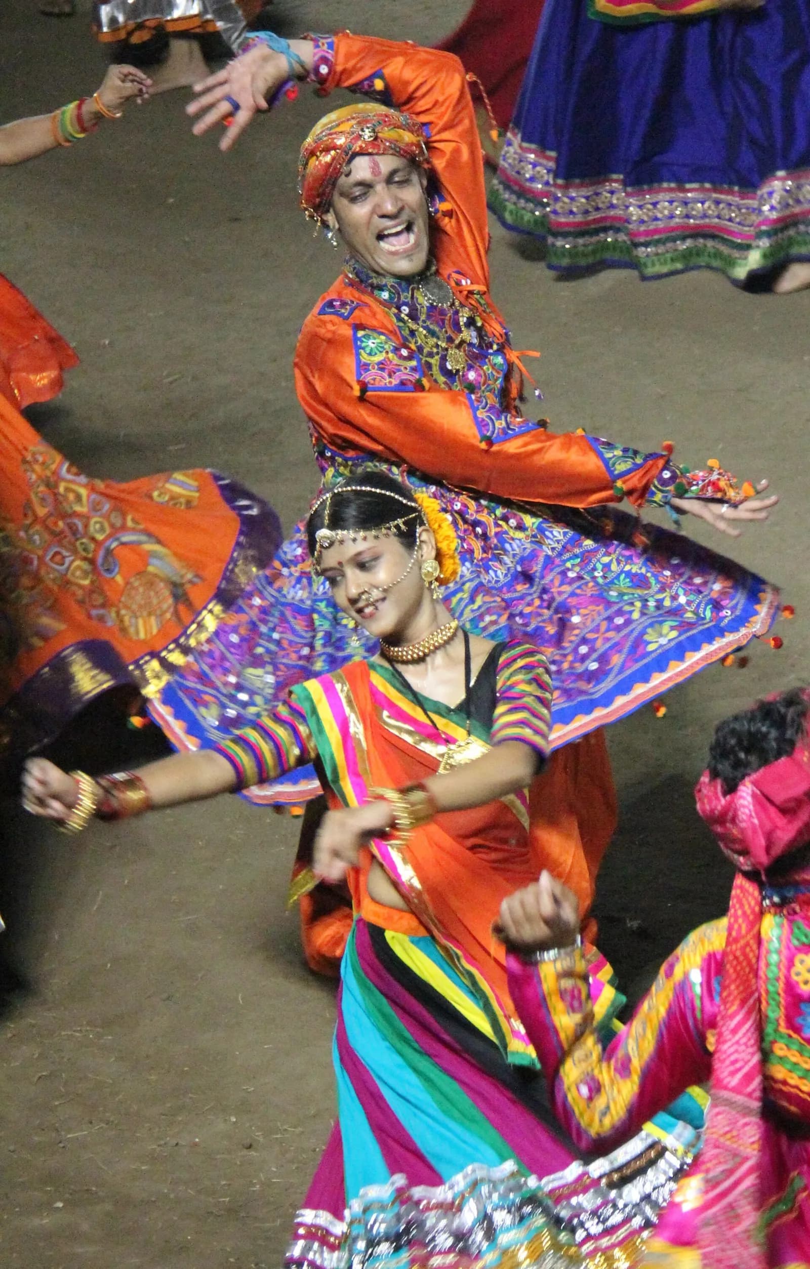 Dancers in chaniya choli circling a lamp-lit garbo during Navratri in Gujarat