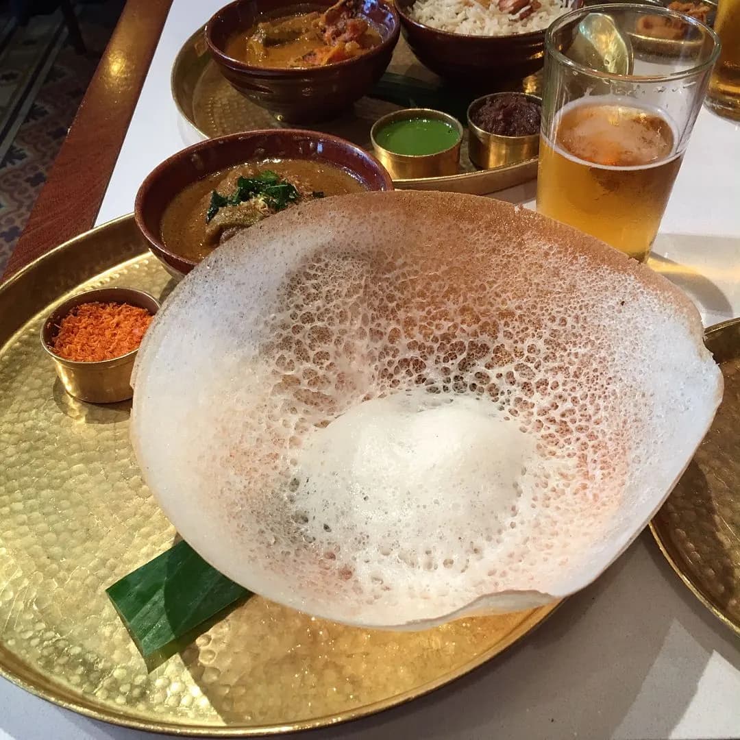 Kerala appam with a bowl of coconut milk stew
