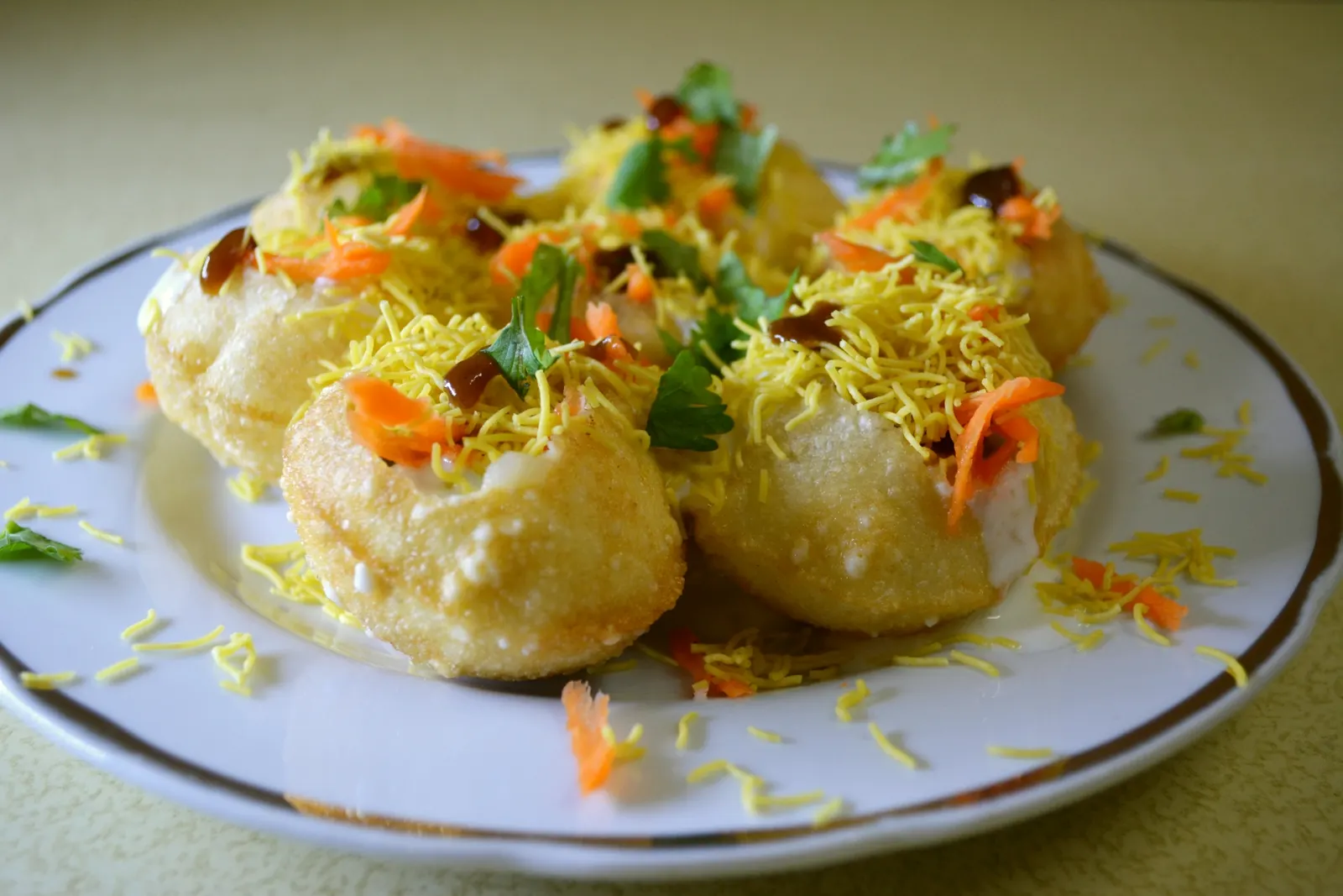 Indian chaat topped with yoghurt, chutney and sev