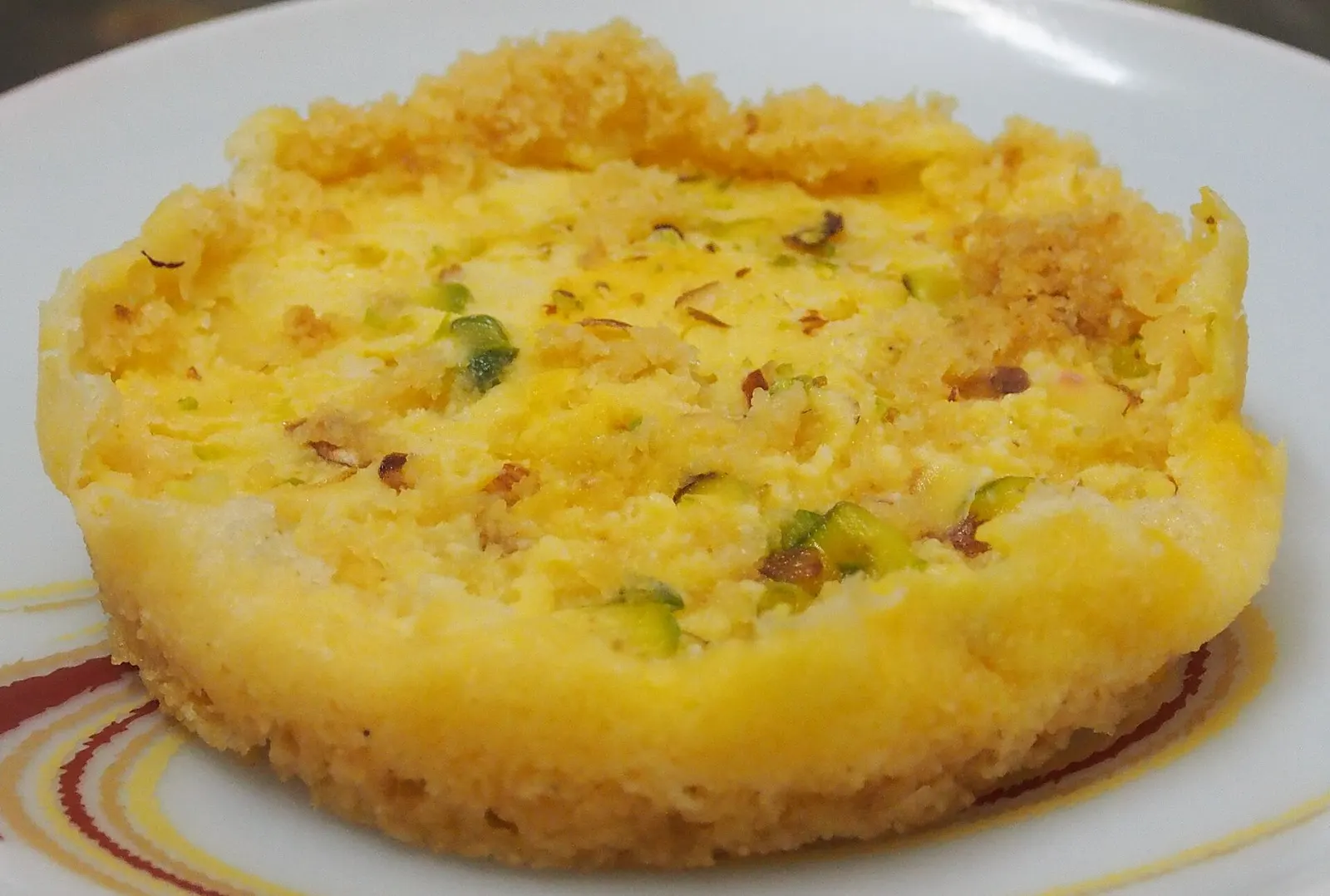 Ghevar topped with rabri and pistachio