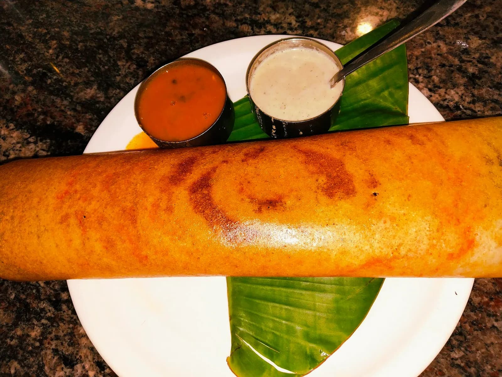 A masala dosa served with chutney and sambar