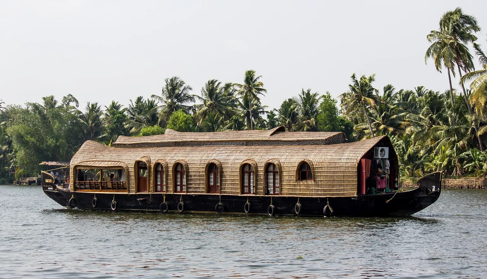 A thatched houseboat drifting through the Kerala backwaters