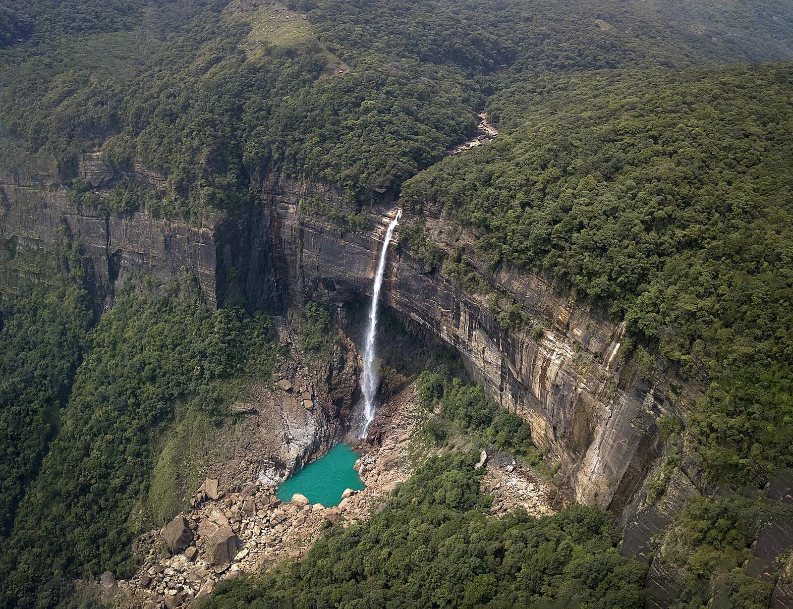 Nohkalikai Falls plunging from the Cherrapunji cliffs into a green pool below